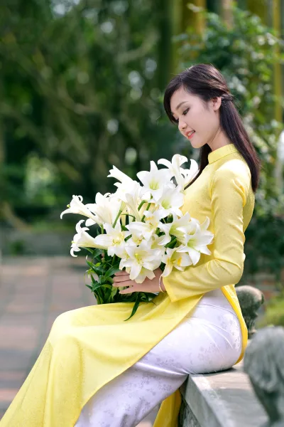 Hình ảnh áo dài vàng truyền thống ngồi dáng điệu đà [UPUDIA]